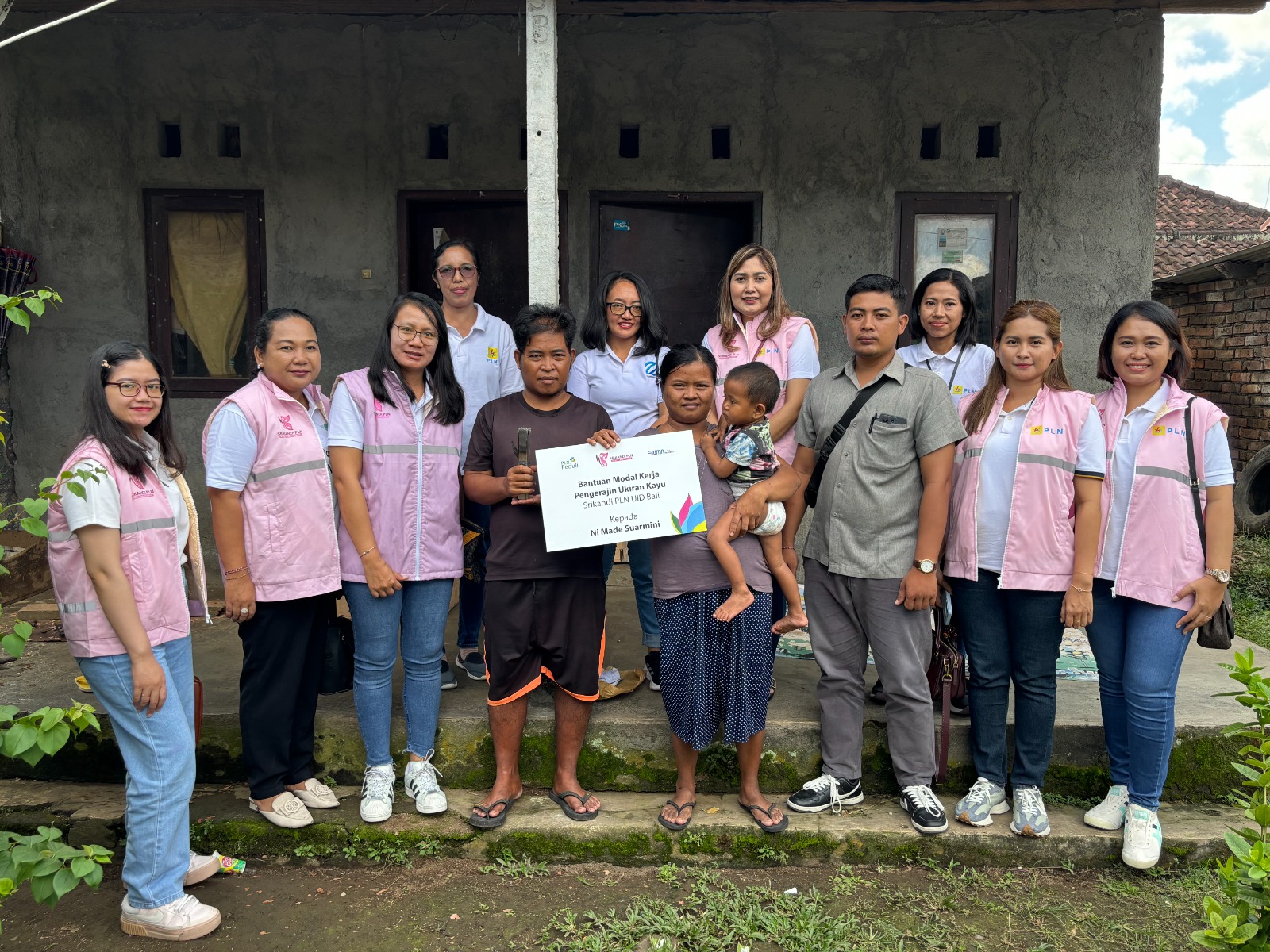 Para Srikandi PLN UID Bali berkumpul di teras halaman rumah salah satu penerima bantuan Ni Made Suarmini saat memberikan bantuan.