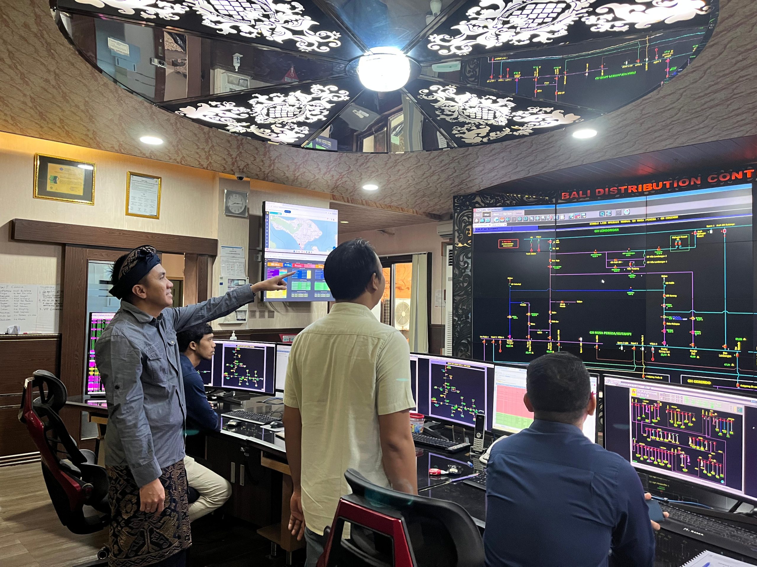 Manager Unit Pelaksana Pengatur Distribusi (UP2D) Bali Munawir Hakim bersama petugas siaga WWF sedang memonitor operasi sistem kelistrikan di Ruang Distribution Control Center (DCC) UP2D Bali.