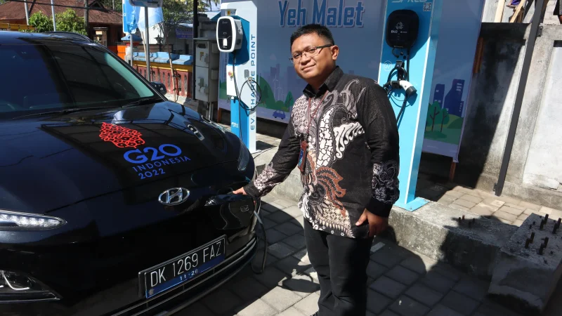 Manager PLN UP3 Bali Timur, Agung Wibowo saat melakukan pengisian ulang daya mobil listrik di SPKLU Yeh Malet, Karangasem.