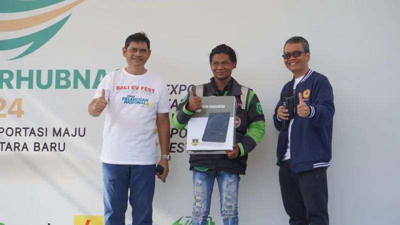 Peserta EV Touring dari Ojek Online (tengah) mendapatkan doorprice atas testimoninya selama ini lebih menguntungkan menggunakan motor listrik sebagai kendaraan untuk bekerja.