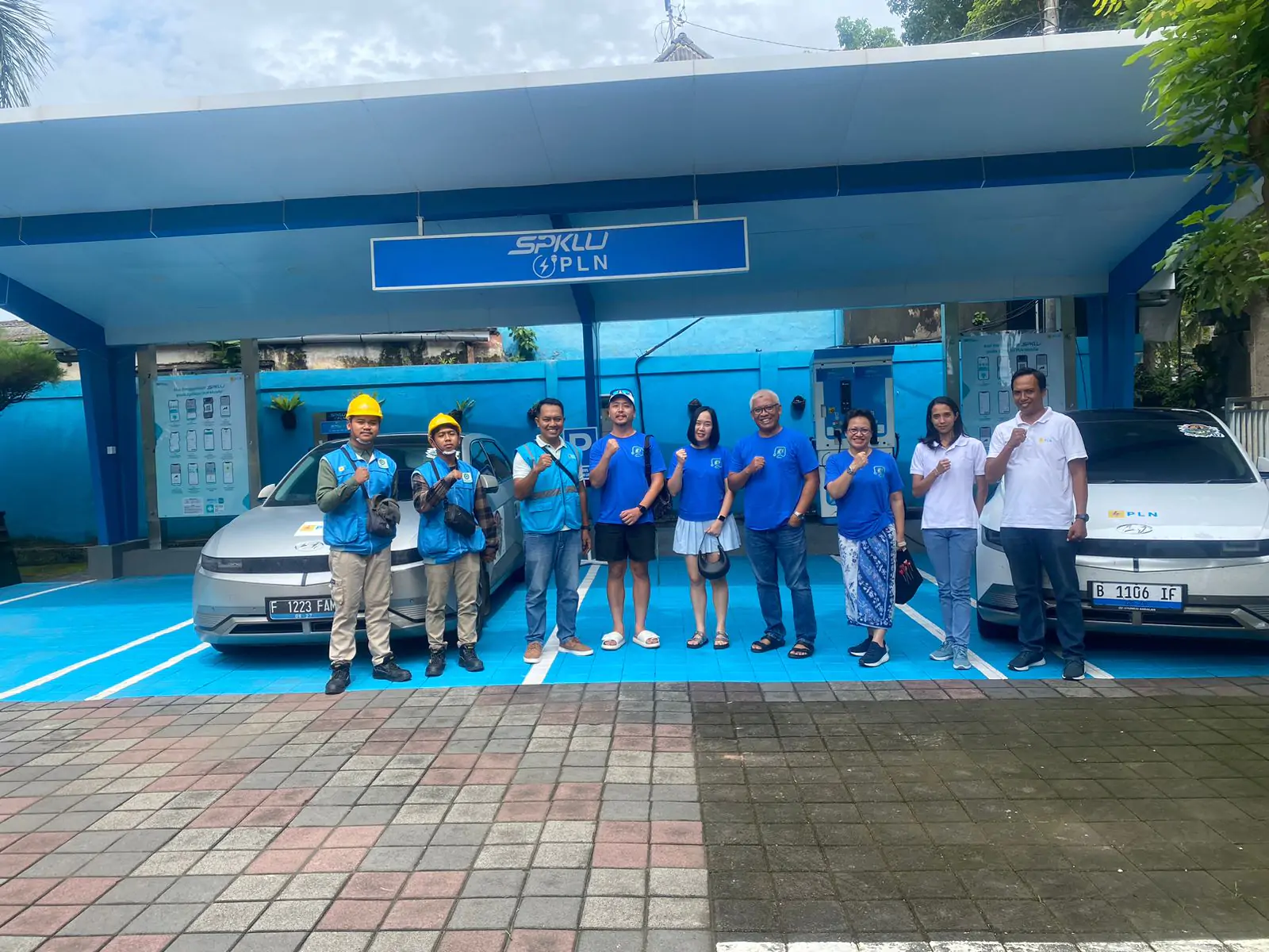 Tim PLN yang siaga di SPKLU menyempatkan berfoto bersama dengan pemilik kendaraan listrik yang sedang charging saat libur Hari Raya Imlek.