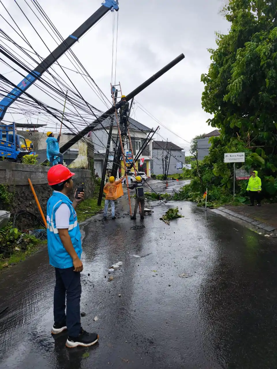 Petugas PLN sedang melakukan perbaikan jaringan listrik ditengah cuaca extrim dan tidak menentu di daerah Kuta Selatan Badung.