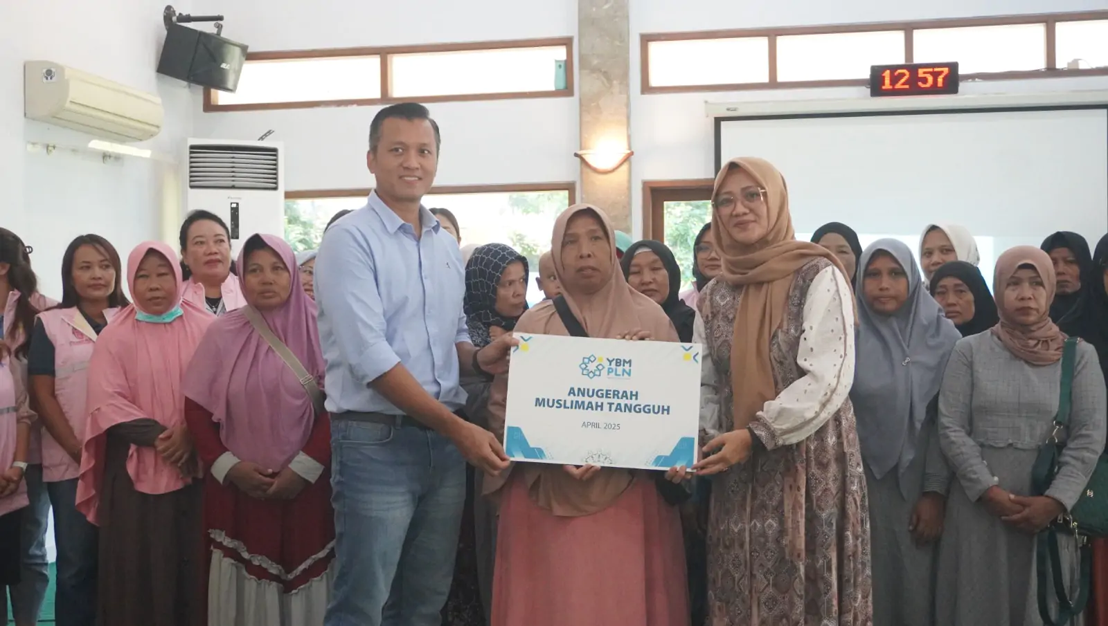 General Manager PT PLN (Persero) UID Bali, Eric Rossi Priyo Nugroho (depan-kiri) menyerahkan bantuan Anugerah Muslimah Tangguh secara simbolis kepada Sitiyah (tengah) didampingi Ketua PIKK PLN UID Bali, Irma Eric Rossi (depan-kanan).
