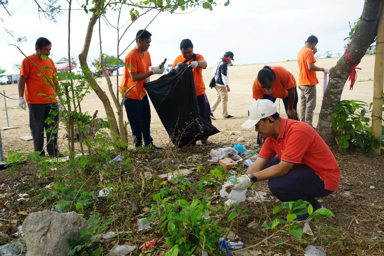 Manajer UP2D Bali Petrus Irwan Ichwansaputra (kanan bertopi putih) sedang melakukan pembersihan sampah plastik di tepi pantai Mertasari bersama dengan karyawan PLN UP2D lainnya.